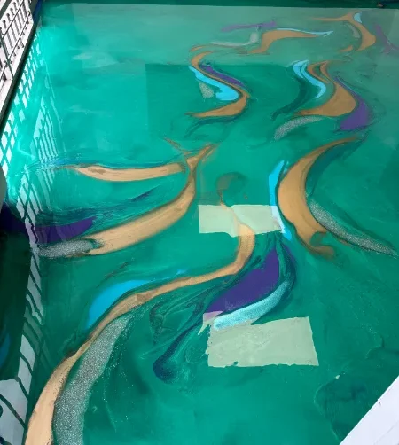 Teal metallic epoxy floor with gold and purple swirls
