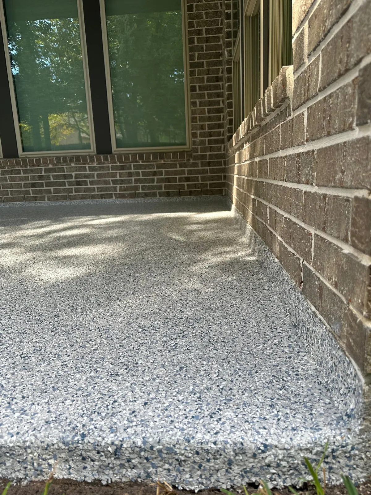 Close-up of epoxy flake patio edge detail with full flake coverage